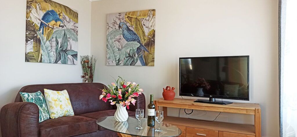 Wohnzimmer mit Sofa, Fernseher und gemütlicher Einrichtung